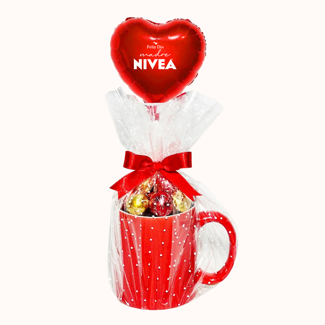 Taza Personalizada corporativa rellena con chocolates, envuelta en papel celofán y acompañada de un globo metálico en forma de corazón personalizado con tu logo y mensaje día de la madre. Ideal para sorprender a clientas y colaboradoras.