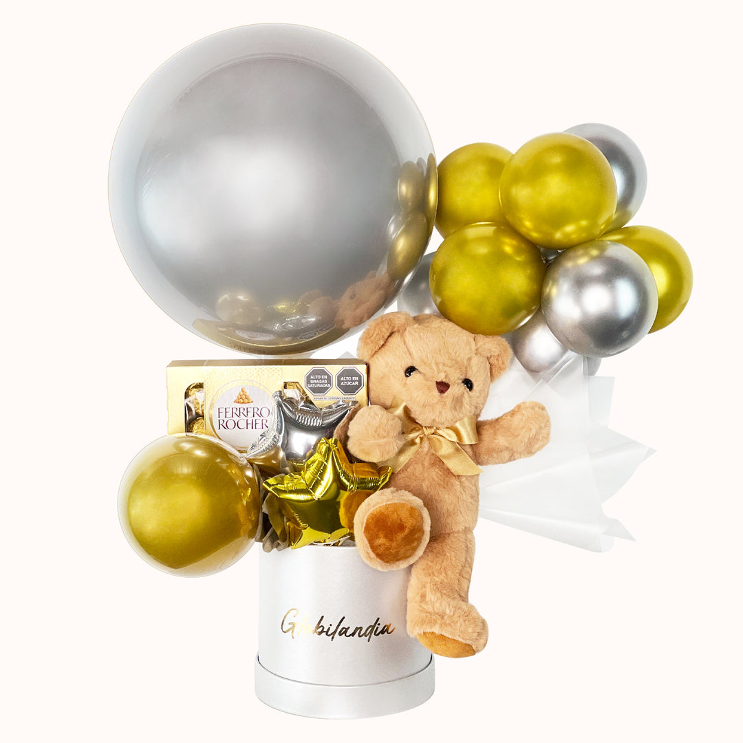 Gift box en colores dorado y plata, ideal para regalar en cumpleaños o cualquier ocasión especial, que incluye 1 peluche de osito mediano, 1 globo burbuja personalizable, 1 caja de Ferrero Rocher (8 unidades), globitos decorativos y caja de regalo deluxe satinada, perfecto para sorprender con un detalle especial.