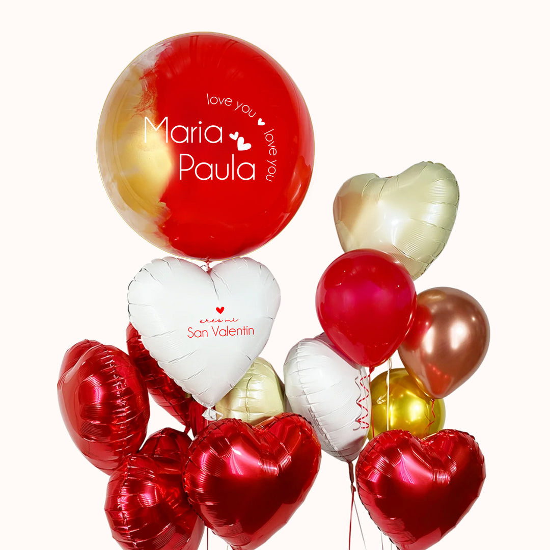 Arreglo con globo burbuja pintado en tonos rojo y dorado, personalizado con la frase “I Love You”, acompañado de 8 globos metálicos de corazón , 1 globo corazón personalizado y 3 globos de látex. Un detalle para regalar en San Valentín o una ocasión especial a tu novio o novia.