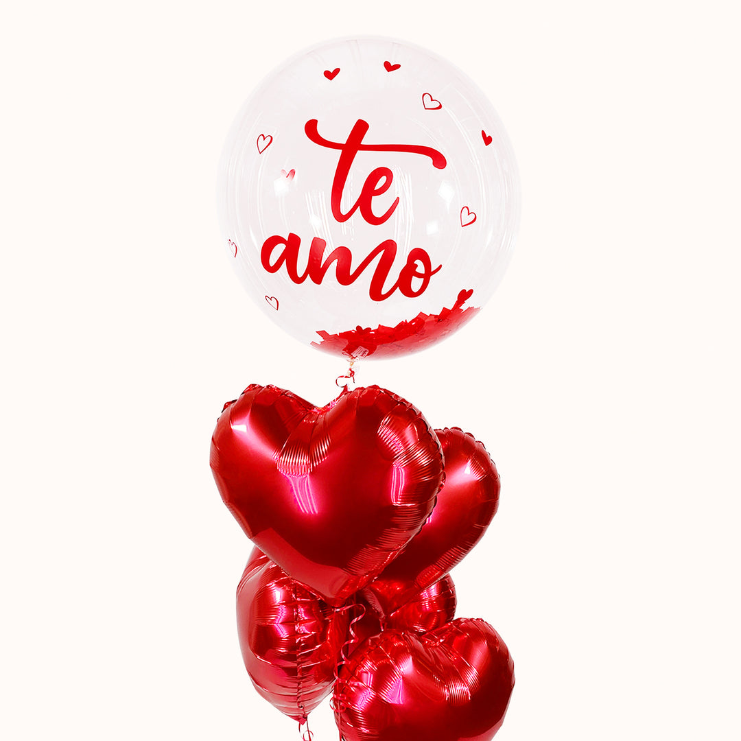 Globo burbuja transparente con texto Globo burbuja transparente con texto rojo 'Te amo' sobre un ramo de 5 globos metálicos rojos en forma de corazón. Un detalle romántico y elegante, ideal para enamorar en San Valentín y sorprender con el regalo perfecto.
