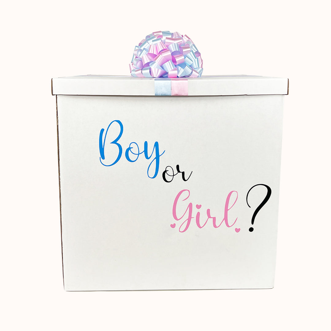 aja blanca vacía para revelación de sexo, con tapa decorada con moño de cinta de agua en rosado y celeste, personalizada con la frase “Boy or Girl” en tonos rosado y celeste.