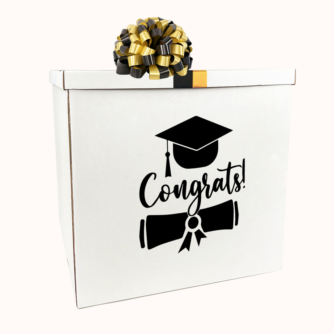 Caja blanca con tapa y moño para sorpresa de graduación, medida 70 cm × 70 cm, decorada en tonos blanco, dorado y negro.