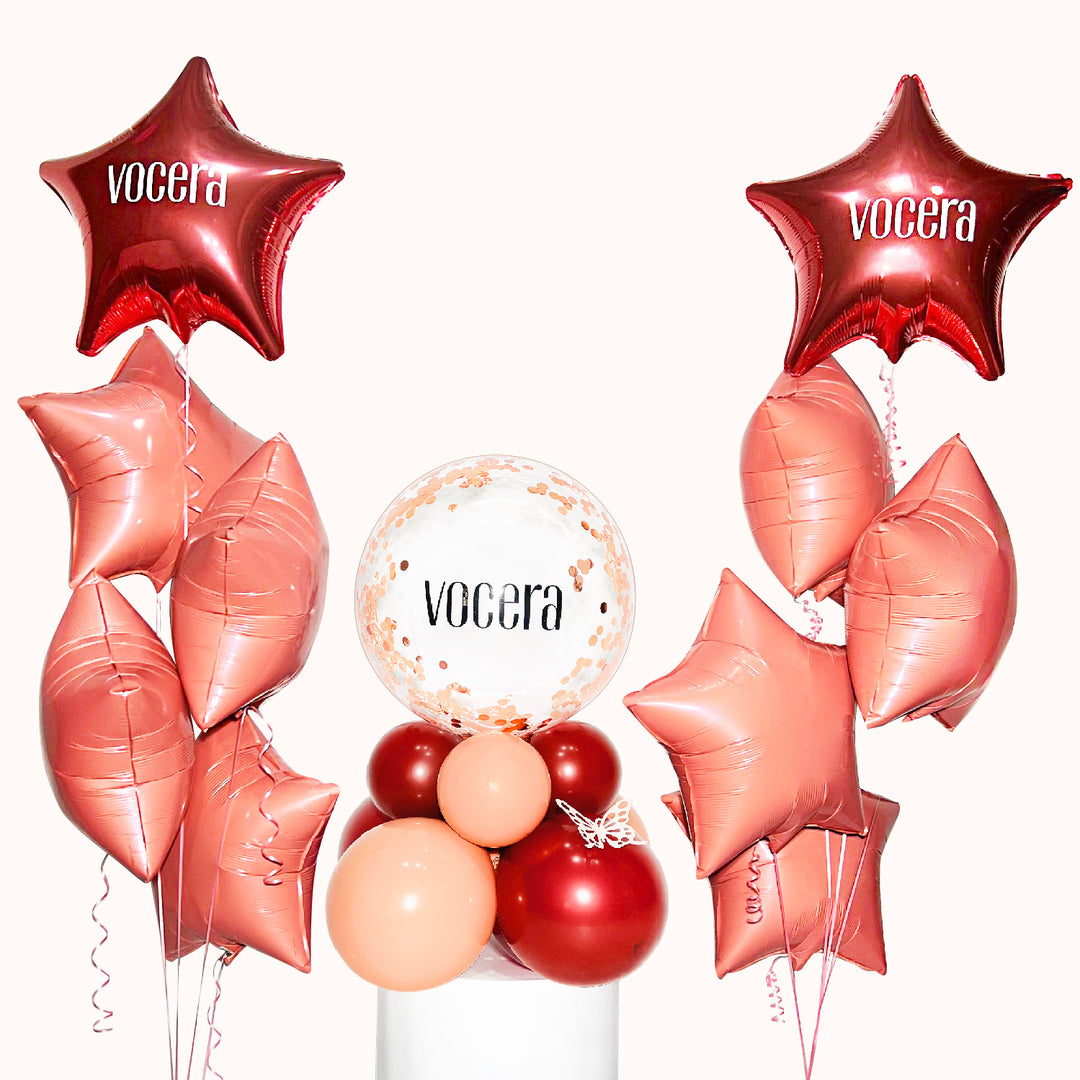 Centro de mesa con globo burbuja y base de globos, acompañado de 10 globos metálicos con helio, distribuidos en 2 bouquets de 5 globos. Promociona tu empresa en eventos corporativos.