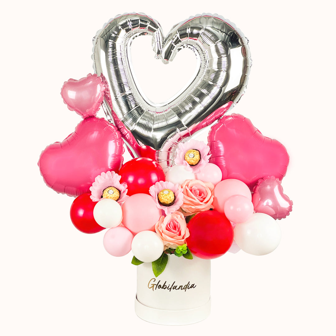 Gift Box con globo metálico en forma de corazón hueco, 2 corazones rosados medianos y 2 globos de corazones pequeños, 2 rosas artificiales decorativas, variedad de globos de látex rojos y rosados y 3 chocolates Ferrero Rocher. Ideal para regalar en San Valentín, Día del Amor y la Amistad.