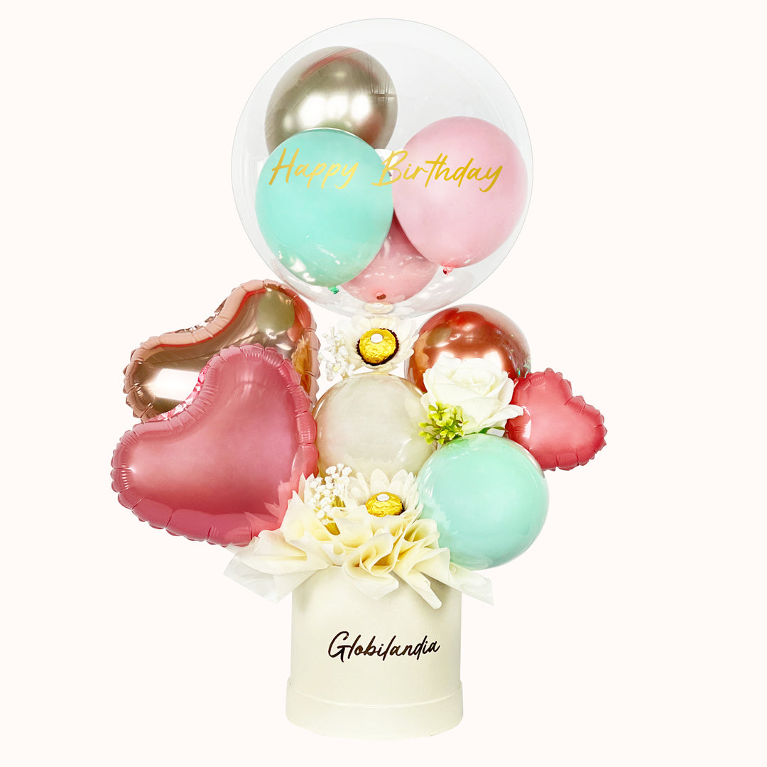 Regalo o detalle en caja satinada, decorada con globos y globo burbuja personalizado con “Happy Birthday”, incluye 3 unidades de chocolate Ferrero Rocher y globos en forma de corazón. Ideal para obsequiar en cumpleaños.