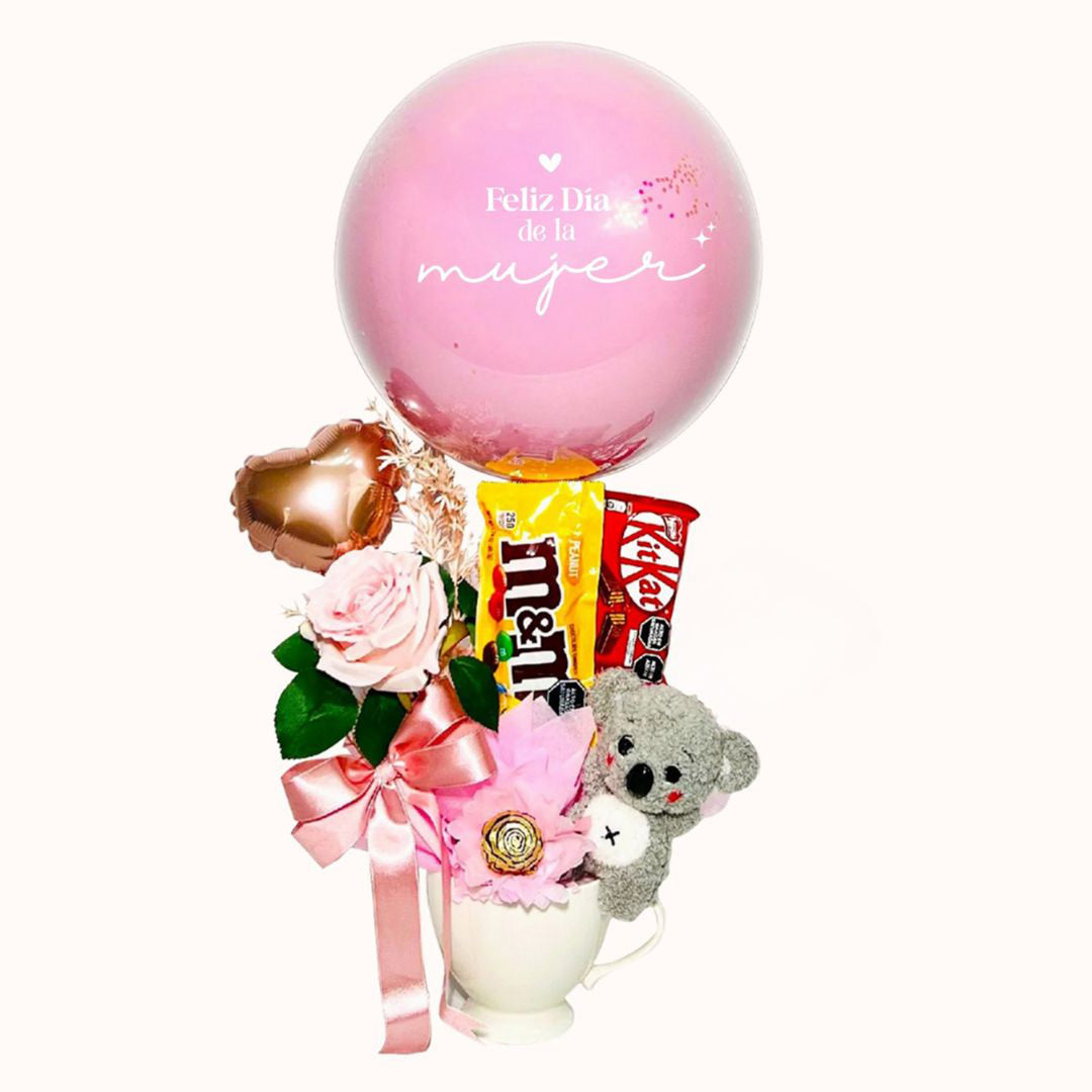 Taza para regalar en el Día de la Mujer. decorada con globo burbuja, rosa decorativa, globos de látex, chocolates importados y peluche chico. 