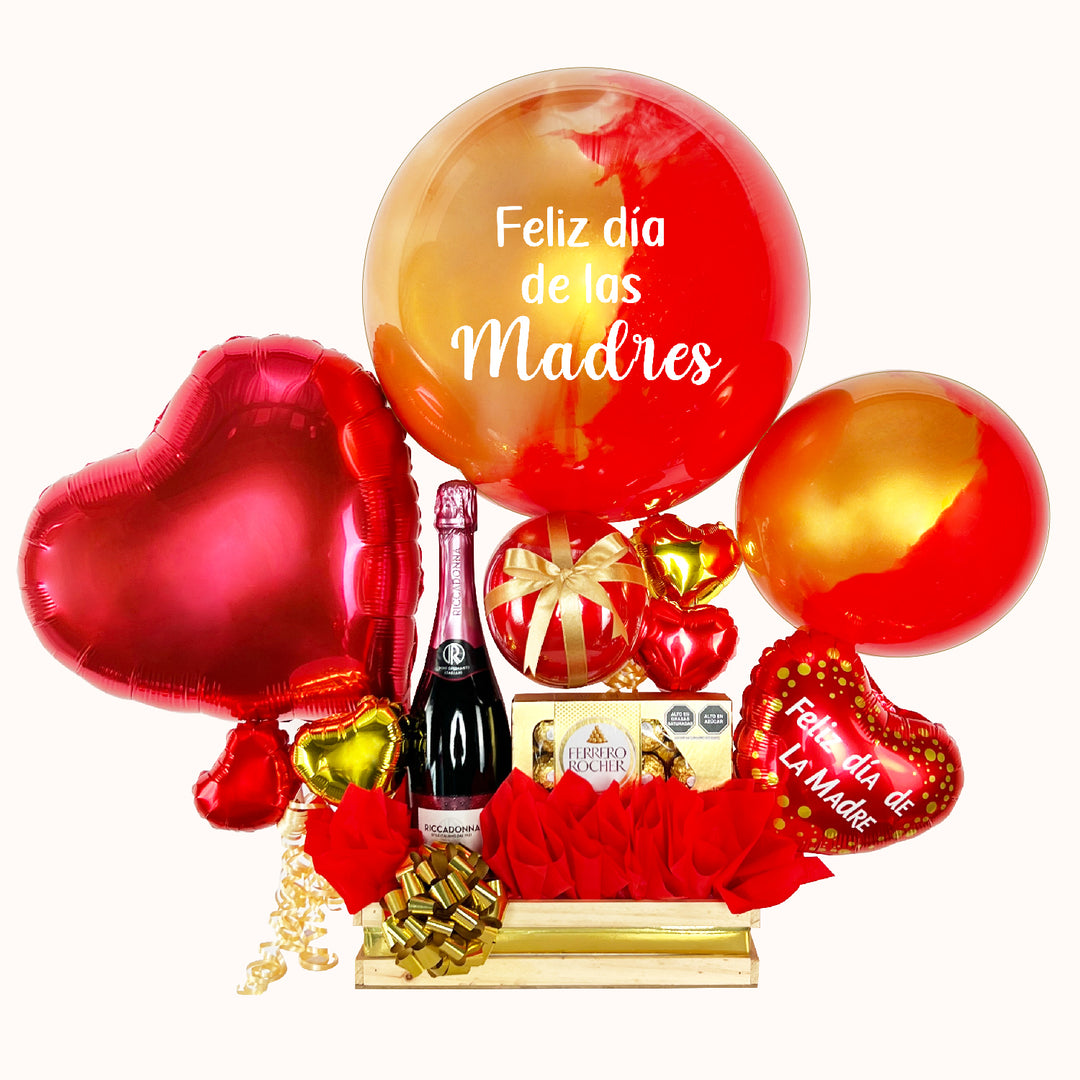 Caja de regalo grande para el Día de la Madre con globo burbuja pintado y personalizado, globos corazón, globo burbuja pequeño pintado, chocolates Ferrero Rocher (8 unid.), botella Riccadonna Ruby 750 ml, globitos decorativos y presentación especial. Ideal para sorprender a mamá en su día.
