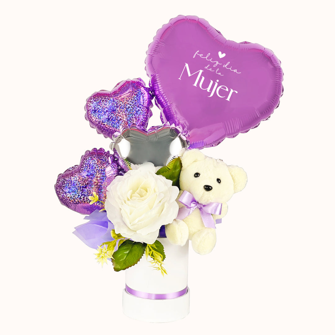 Detalle para regalar en el Día de la Mujer: mini gift box en base circular, con osito de peluche y globitos en tonos lila y plata.