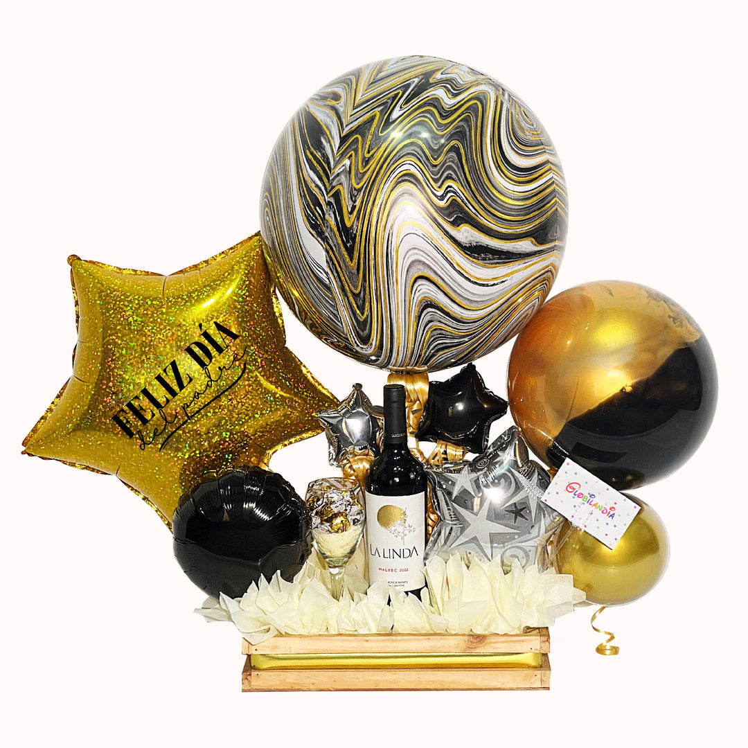 Gift box en tonos plata, dorado y negro, incluye una botella de vino de 750 mL y globos decorativos. Un regalo especial para papá en su día.