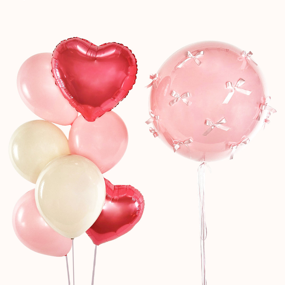 Bouquet de 8 globos con helio: 1 globo burbuja con globo en su interior, decorado con lazos; 2 globos corazón metálicos y 4 globos de látex, en tonos arena y rosado. Ideal para celebrar cualquier ocasión especial. Personalizable.