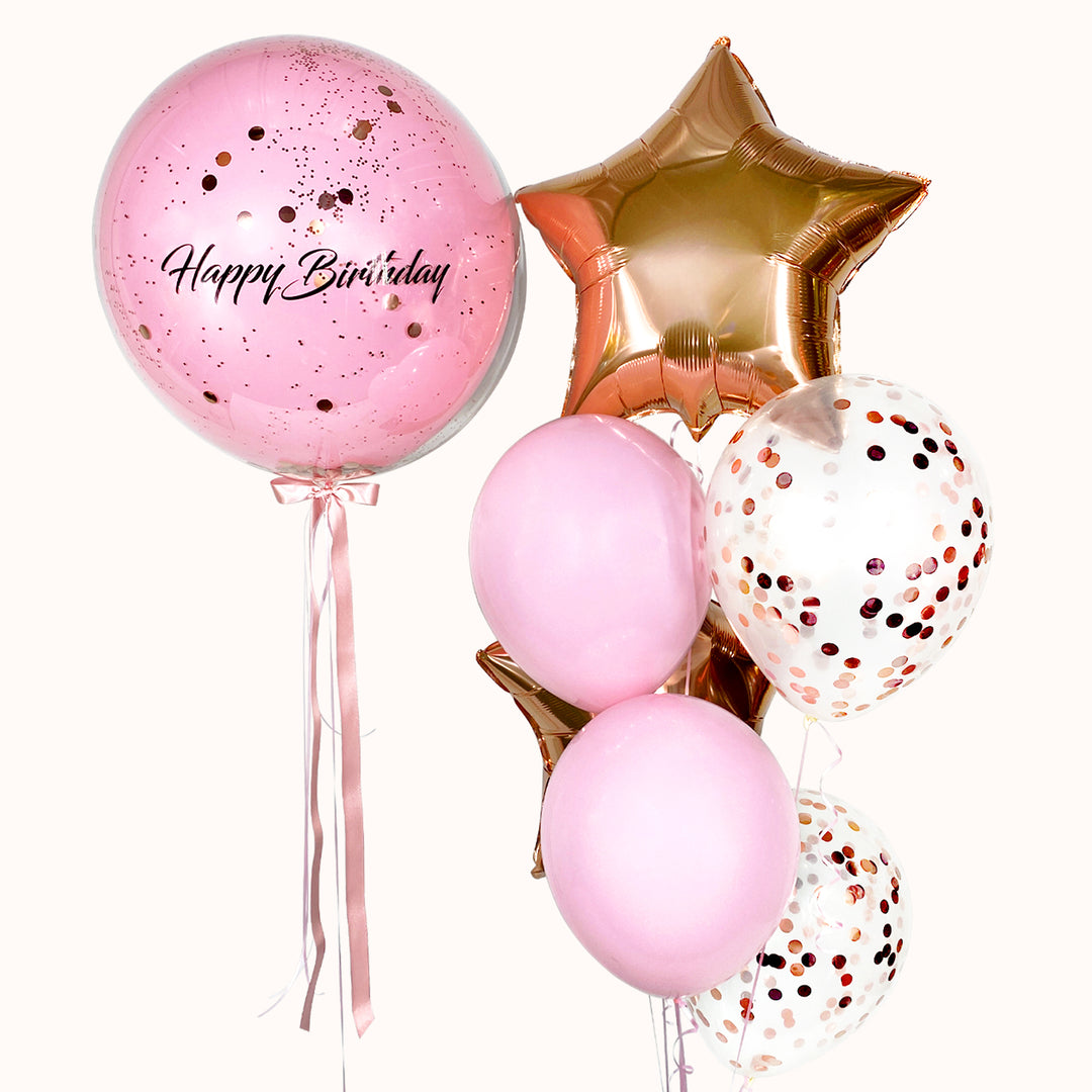 Bouquet de 7 globos con helio: 1 burbuja con globo interno rosado, personalizada con logo; 2 globos estrella metálicos, globos de látex y 2 globos con confeti. Ideal para decorar cumpleaños o cualquier ocasión. Color a elección.