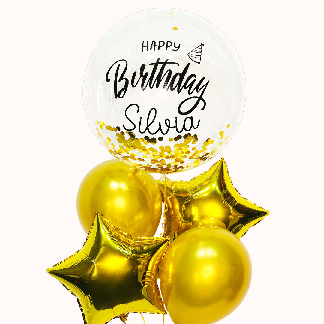 Ramo de 5 globos: 1 burbuja transparente con confeti dorado, 2 globos de látex dorados y 2 globos estrella dorados. Inflados con helio puro, ideal para celebrar cumpleaños o cualquier ocasión especial.