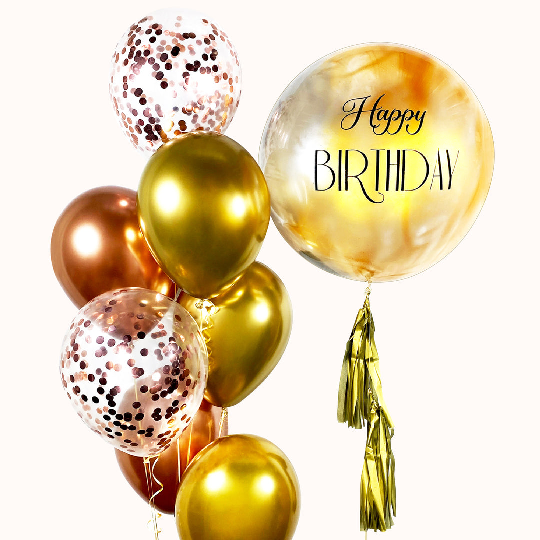 Bouquet de globos para cumpleaños en color dorado y rose gold. Incluye 1 globo burbuja pintado y personalizado, 5 globos de látex  y 2 globos de látex transparentes con confetti. 
