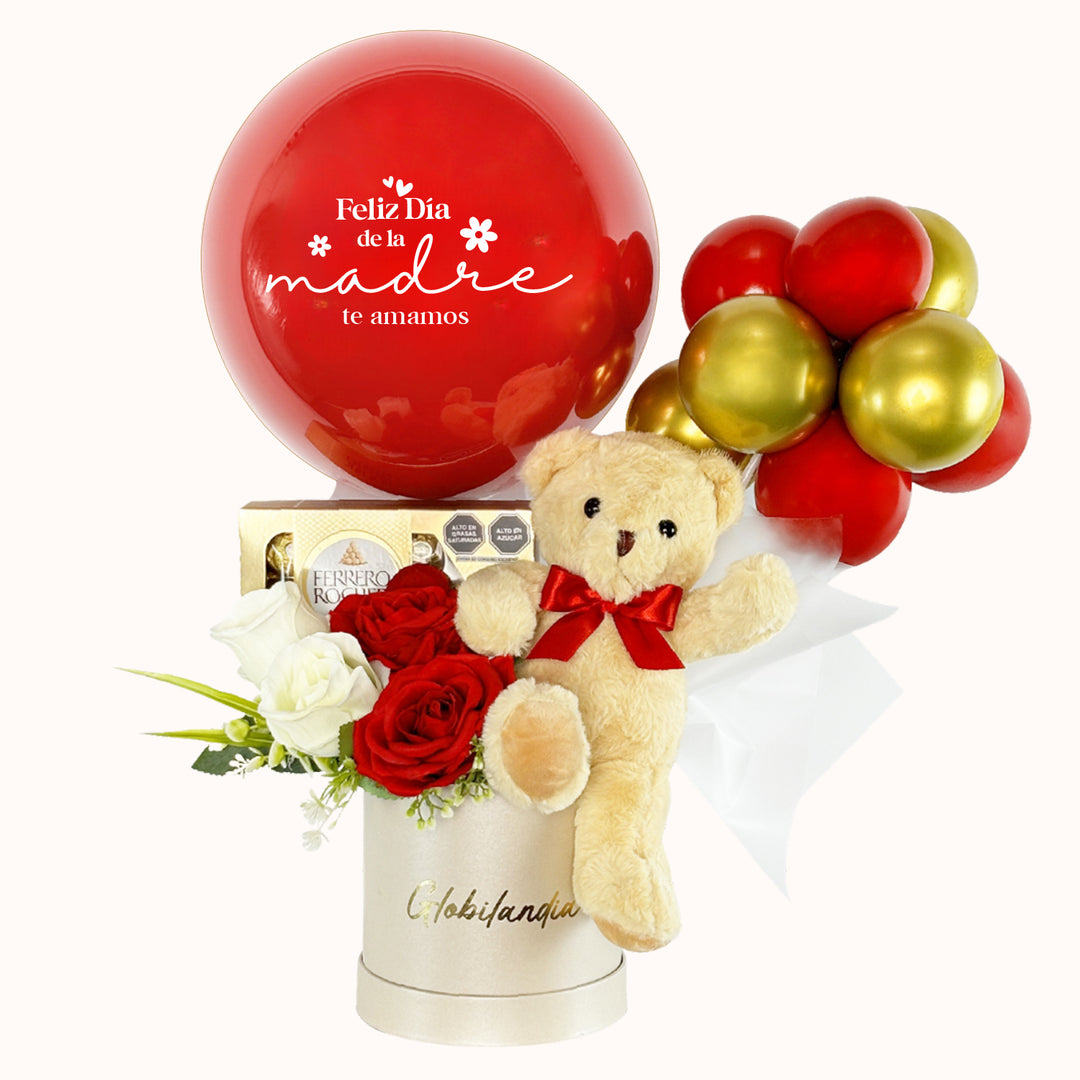 Caja de regalo deluxe con peluche de osito mediano, globo burbuja personalizable, chocolates Ferrero Rocher (8 unid.) y globitos decorativos. Ideal para sorprender a mamá en el Día de la Madre.