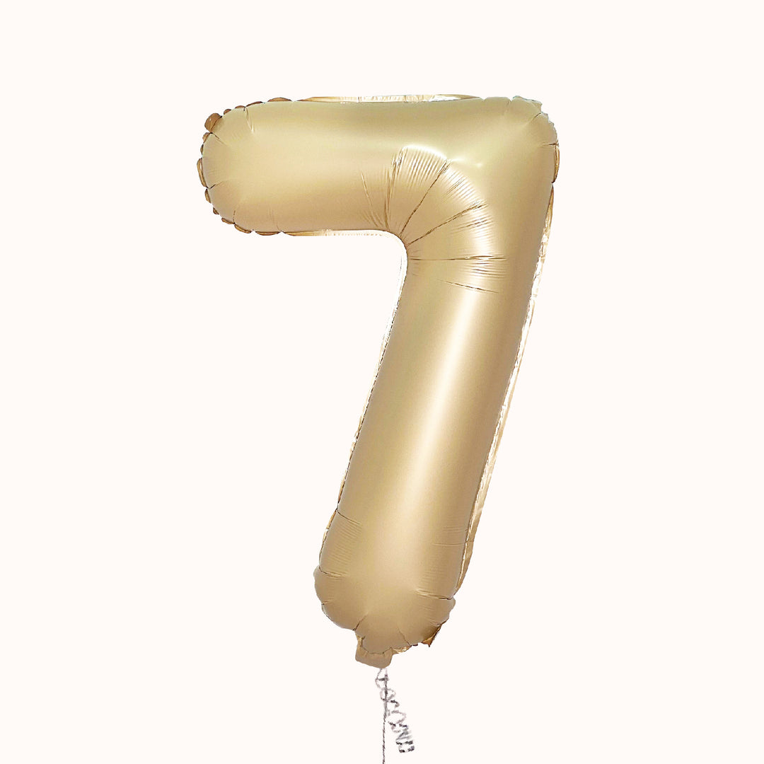 Globo metálico de número en color arena-caramelo, inflado con helio, para cumpleaños o aniversario.