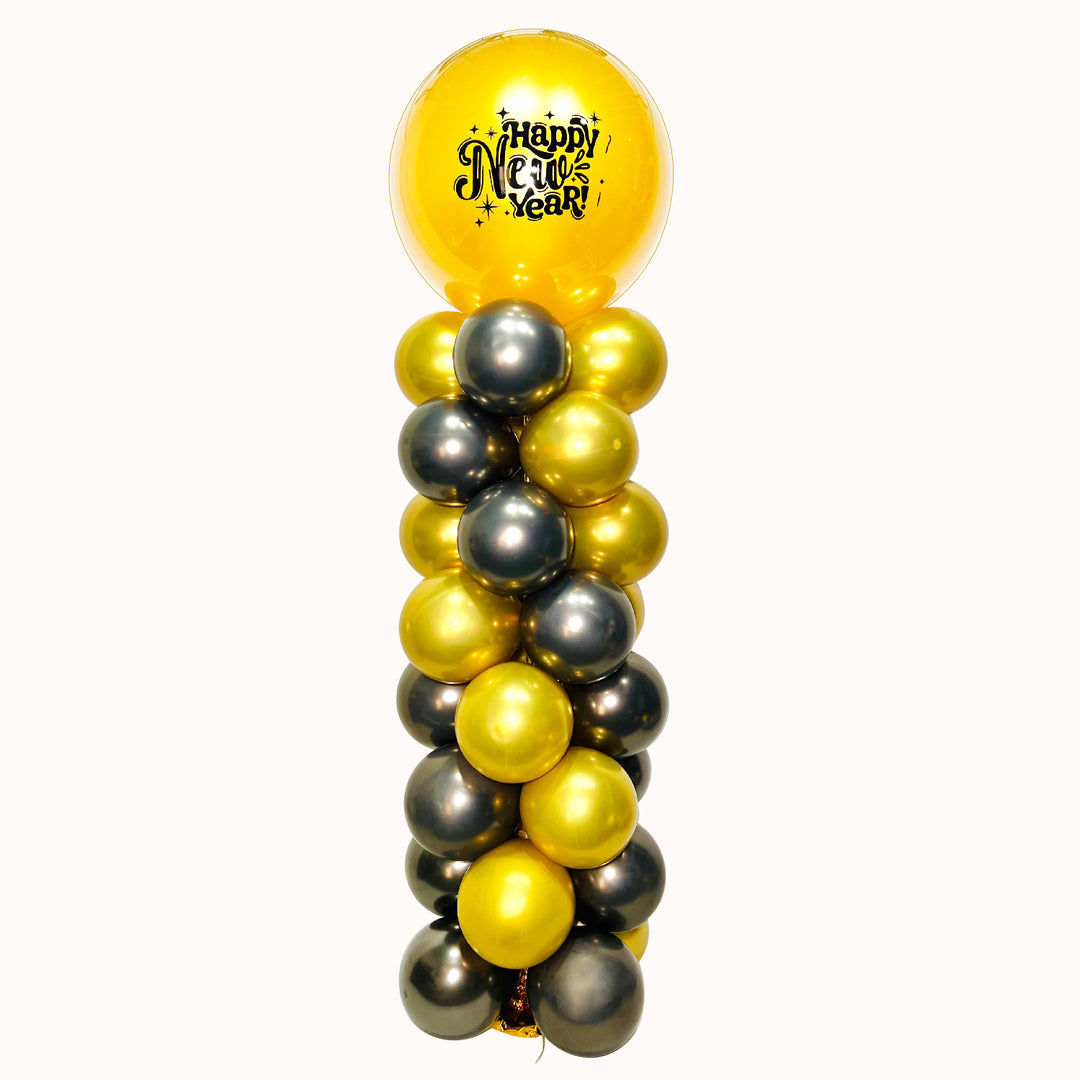 Imponente parante decorativo tipo columna de 180 cm, diseñado en elegantes tonos negro y dorado, con el mensaje “Happy New Year”. Ideal para realzar cualquier espacio, crear un punto focal impactante y aportar un toque sofisticado y festivo a tu celebración de fin de año.