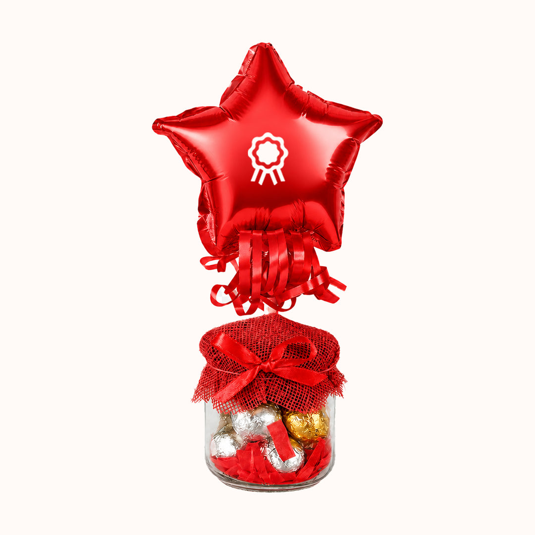 Pomo de vidrio relleno con chocolates Bolibol, acompañado de globo personalizado con tu logo. Ideal como regalo para colaboradores y clientes. Fiestas patrias