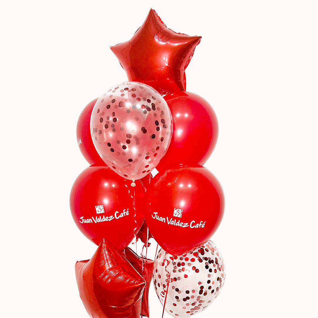 Bouquet corporativo para Fiestas Patrias que incluye 4 globos metálicos en forma de estrella de color sólido, 2 globos de látex transparentes con confetti, 4 globos de látex de color sólido personalizados con el logo de tu empresa y 1 pesa. Ideal para la decoración de oficinas, recepciones y eventos corporativos, así como para reforzar la presencia de tu marca durante la campaña de Fiestas Patrias.