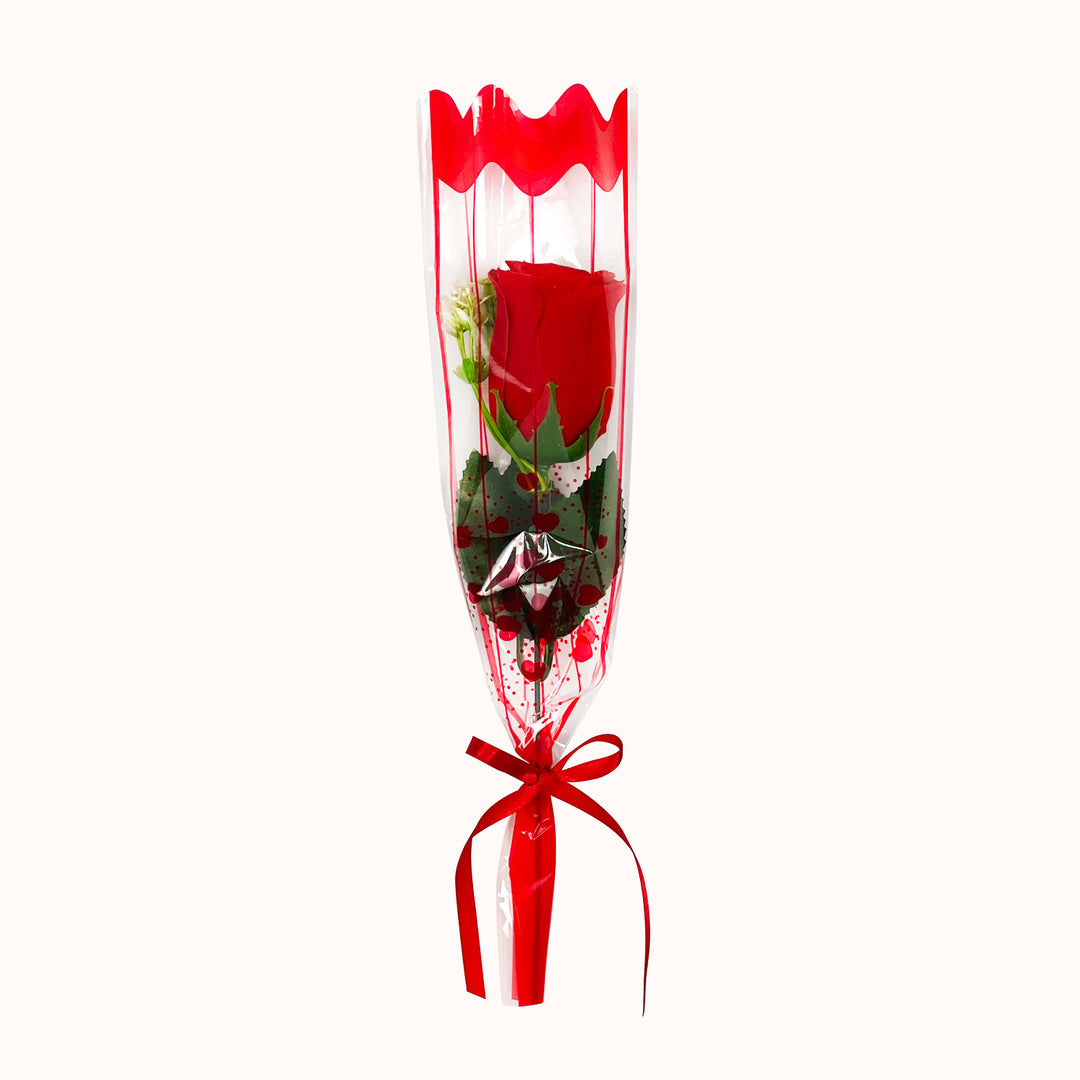 Detalle corporativo para el Día de la Madre con rosa decorativa artificial, envoltura en papel celofán y lazo decorativo. Ideal para campañas empresariales.