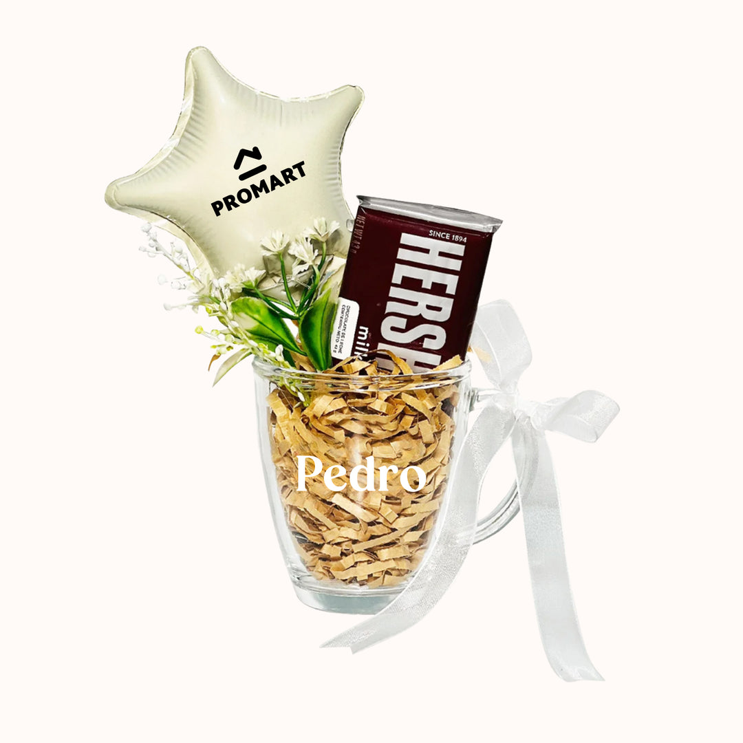 Hermosa taza transparente decorada con flores artificiales, globo personalizado con tu logo y delicioso chocolate importado. Ideal para sorprender a colaboradores el día del trabajo