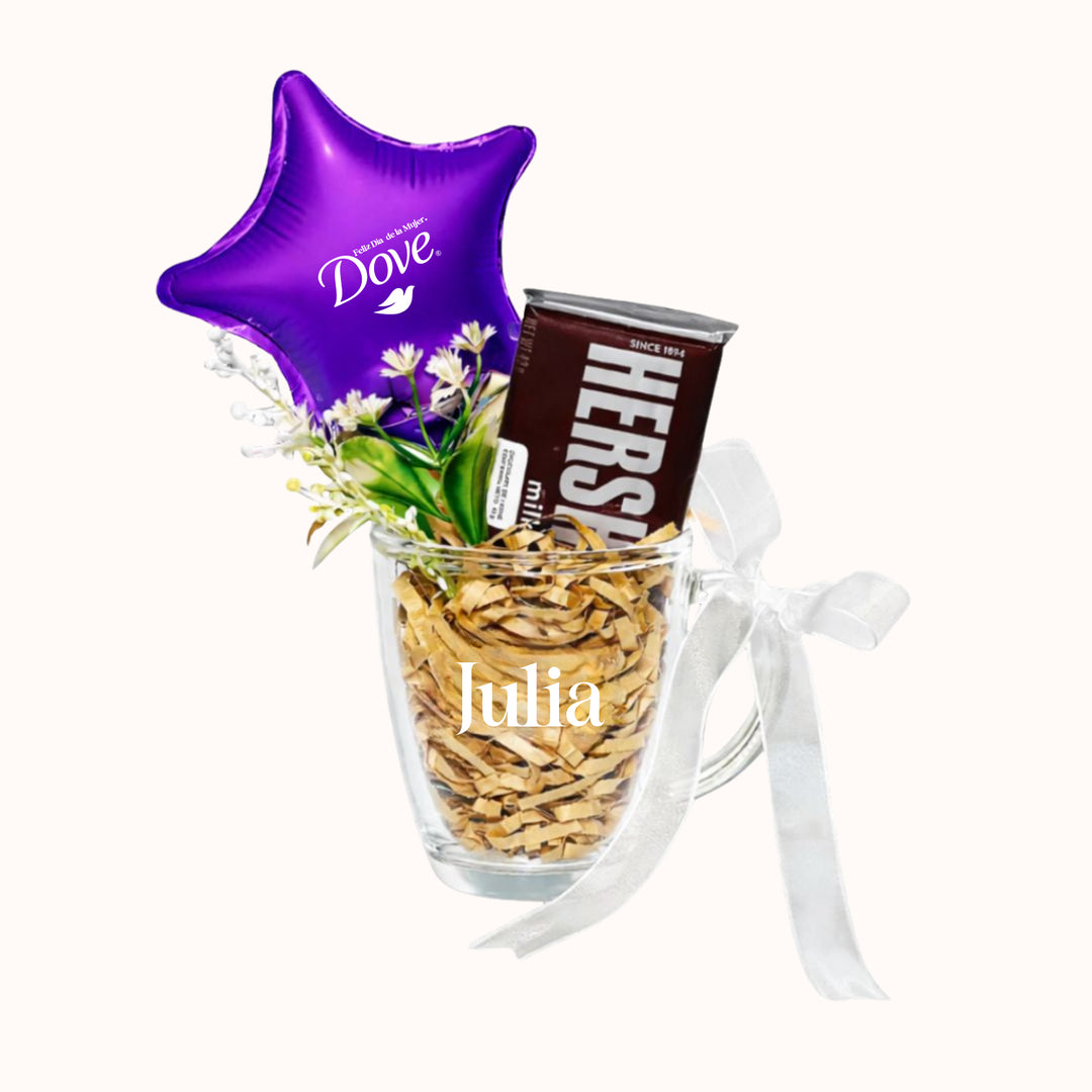 Arreglo corporativo para la campaña del Día de la Mujer que incluye 1 taza de vidrio personalizada, 1 chocolate en barra Hershey, 1 globito pequeño personalizado con logo y flores o plantitas decorativas para obsequios empresariales.